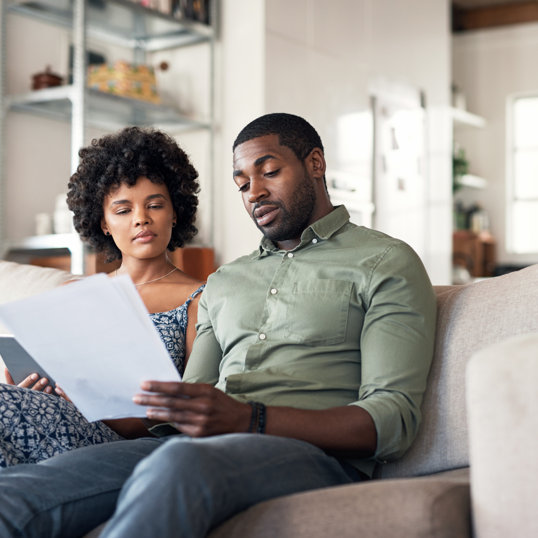 Man & Woman Reading a Document on the couch