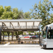 Man waiting for bus working on computer